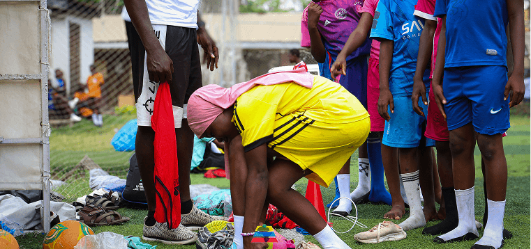 A coach helping a young athlete prepare for training